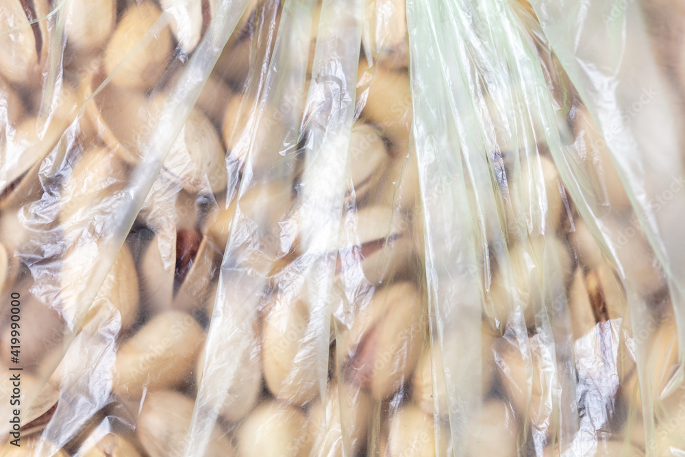Pistachios in a plastic bag as a background.