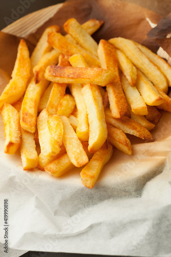 Home made oven baked french fries on kitchen paper. Fast, unhealthy food.