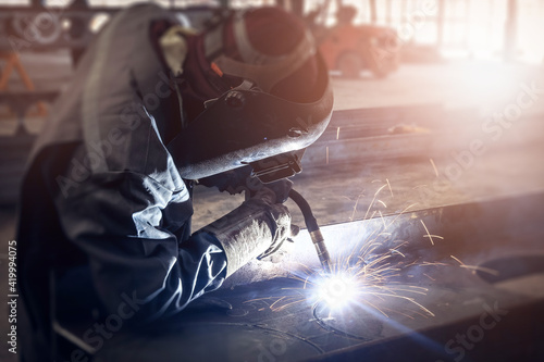 Cutting of steel beam with sparks fly from gas in fabrication factory.
