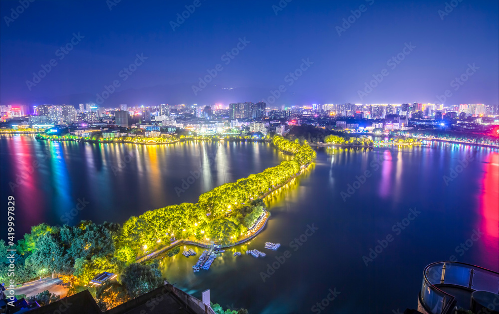 Night view: Overlooking the skyline of a city in southern China surrounded by mountains and rivers. Jiujiang, a medium-sized city in the Yangtze River Economic Belt, is located in the upstream of Shan