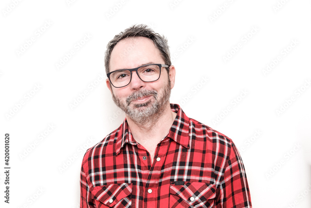 Portrait of a smiling mature man with beard wearing red plaid shirt and glasses. Portrait of a smiling mature man with beard wearing red plaid shirt and glasses.