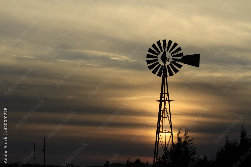 Windmill out in the country at Sunset with a colorful sky west of Nickerson Kansas USA . Windmill out in the country at Sunset with a colorful sky west of Nickerson Kansas USA .