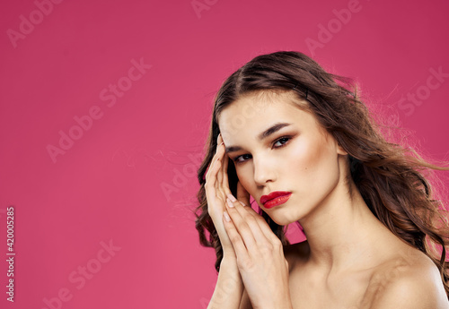 Romantic woman with red lips posing on a pink background