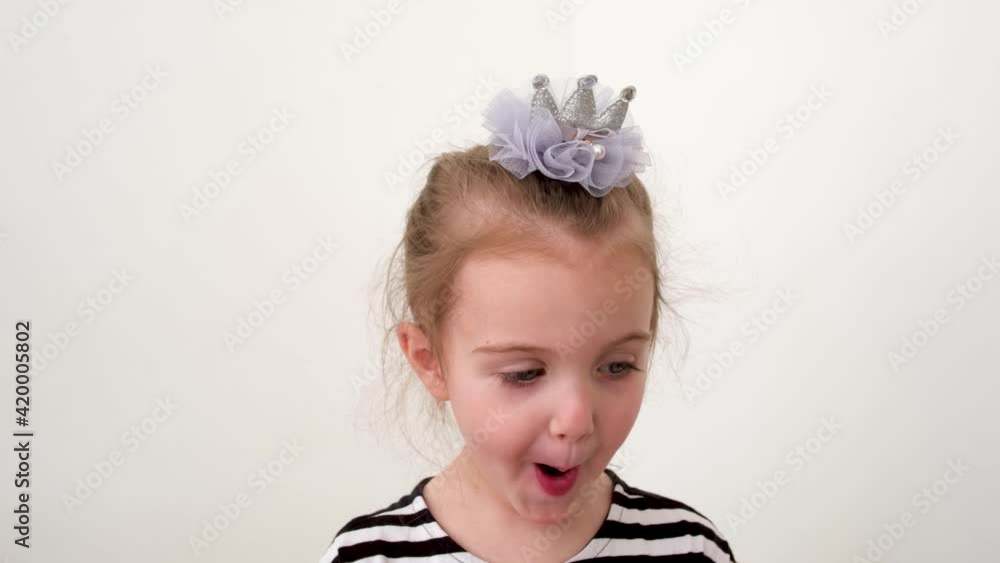 Cute little girl is surprised. Girl looks and is surprised and happy Portrait little young girl with blue eyes looking at camera. Closeup Cute little girl is surprised. Girl looks and is surprised and happy Portrait little young girl with blue eyes looking at camera. Closeup
