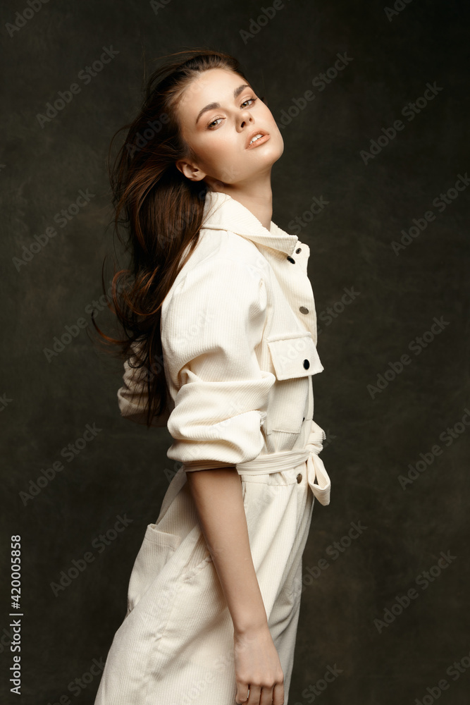 beautiful woman in a light suit on a dark background leaned back side view beautiful woman in a light suit on a dark background leaned back side view