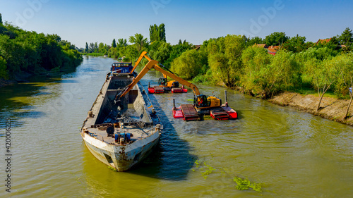 Fototapeta Naklejka Na Ścianę i Meble -  Aerial view of river, canal is being dredged by excavators