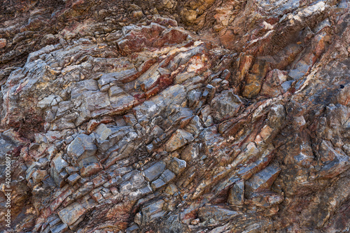 Natural rock stone background. Mining cliff rough front surface.