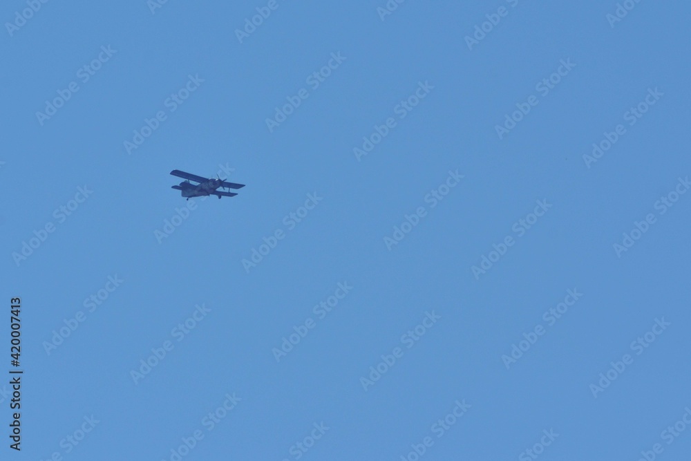 small plane with propellers flying in the blue sky. means of air transport small plane with propellers flying in the blue sky. means of air transport