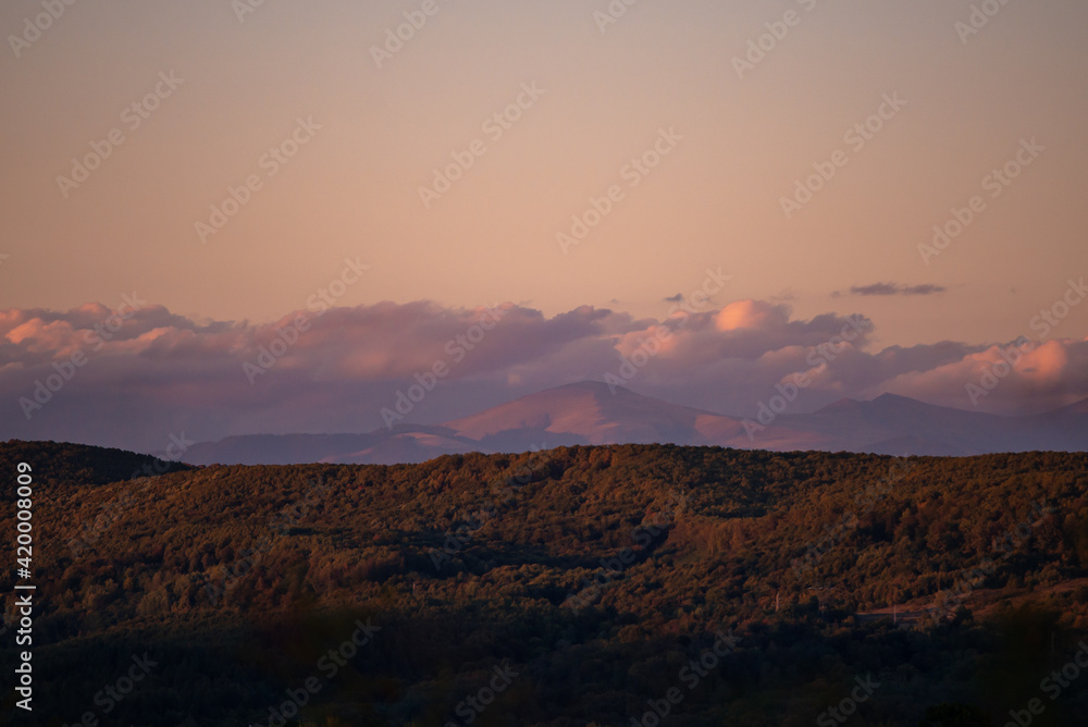 fall landscape overlooking the horizon where the ridges of the high mountains can be seen. high hills full of dense forests at sunset fall landscape overlooking the horizon where the ridges of the high mountains can be seen. high hills full of dense forests at sunset