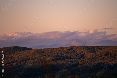 fall landscape overlooking the horizon where the ridges of the high mountains can be seen. high hills full of dense forests at sunset