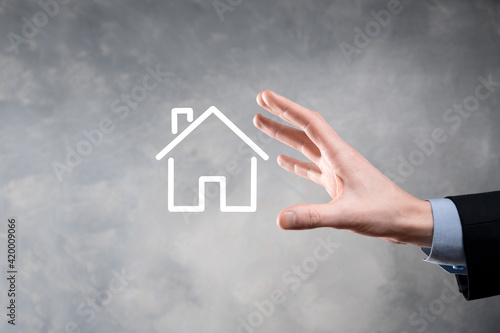 Real estate concept  businessman holding a house icon.House on Hand.Property insurance and security concept. Protecting gesture of man and symbol of house