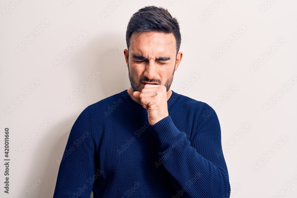 Obraz premium Young handsome man with beard wearing casual sweater standing over white background feeling unwell and coughing as symptom for cold or bronchitis. Health care concept.