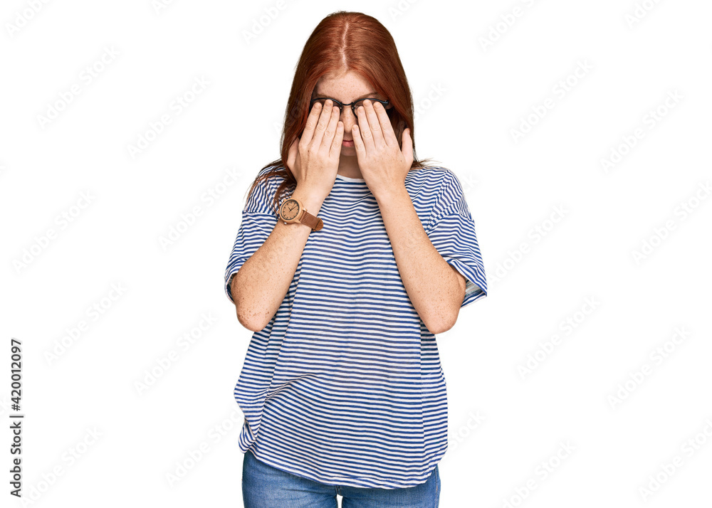 Young read head woman wearing casual clothes and glasses rubbing eyes for fatigue and headache, sleepy and tired expression. vision problem Young read head woman wearing casual clothes and glasses rubbing eyes for fatigue and headache, sleepy and tired expression. vision problem