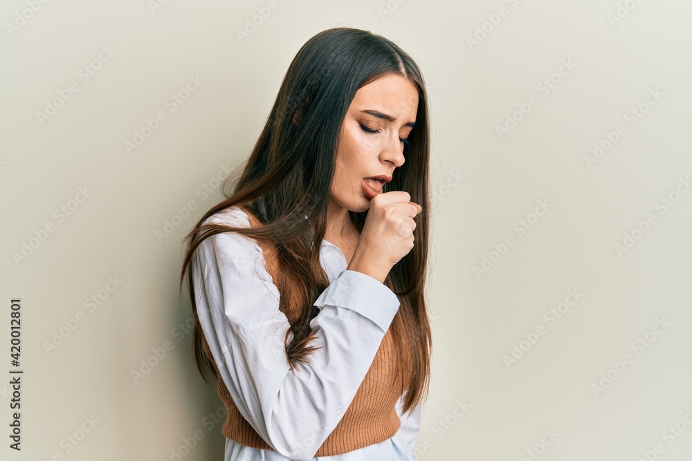 Beautiful brunette young woman wearing casual clothes feeling unwell and coughing as symptom for cold or bronchitis. health care concept. Beautiful brunette young woman wearing casual clothes feeling unwell and coughing as symptom for cold or bronchitis. health care concept.
