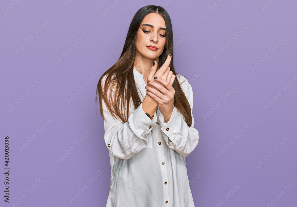 Young beautiful woman wearing casual white shirt suffering pain on hands and fingers, arthritis inflammation Young beautiful woman wearing casual white shirt suffering pain on hands and fingers, arthritis inflammation