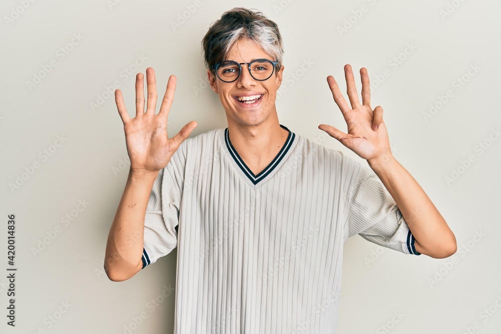 Young hispanic man wearing casual clothes and glasses showing and pointing up with fingers number nine while smiling confident and happy. Young hispanic man wearing casual clothes and glasses showing and pointing up with fingers number nine while smiling confident and happy.