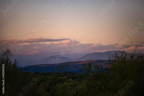 Fototapeta Naklejka Na Ścianę i Meble -  fall landscape overlooking the horizon where the ridges of the high mountains can be seen. high hills full of dense forests at sunset