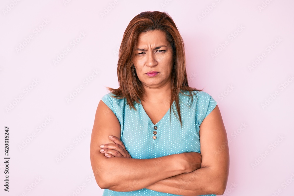 Middle age brunette hispanic woman wearing casual clothes skeptic and nervous, disapproving expression on face with crossed arms. negative person. Middle age brunette hispanic woman wearing casual clothes skeptic and nervous, disapproving expression on face with crossed arms. negative person.