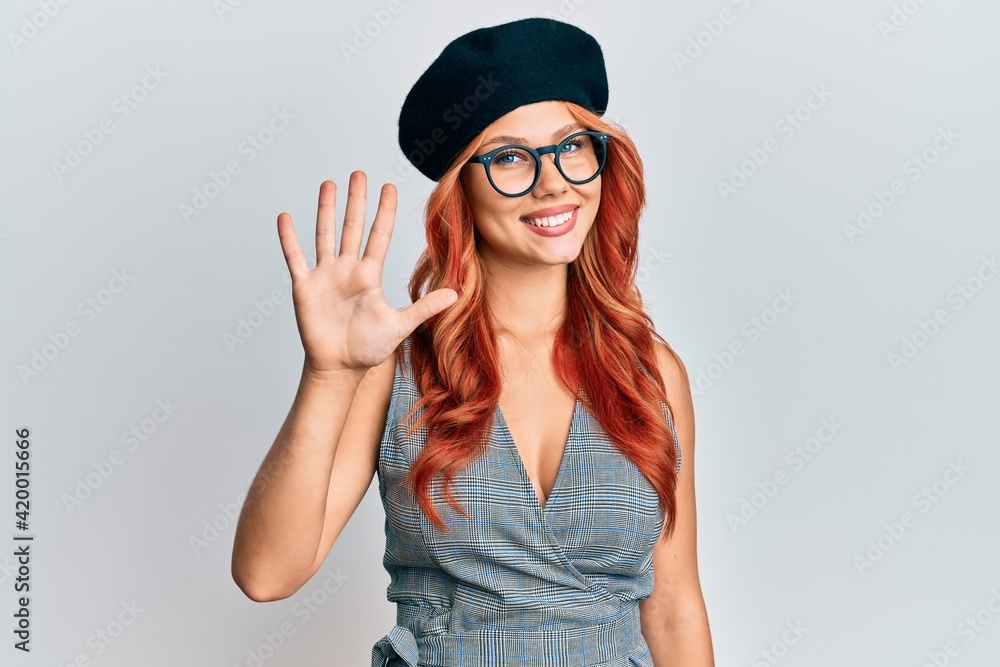 Young redhead woman wearing fashion french look with beret showing and pointing up with fingers number five while smiling confident and happy. Young redhead woman wearing fashion french look with beret showing and pointing up with fingers number five while smiling confident and happy.
