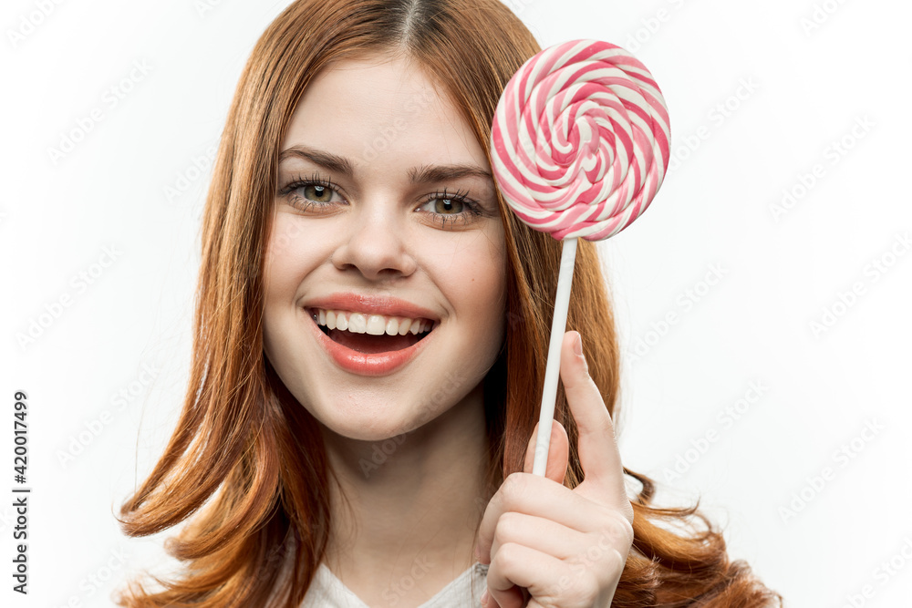 woman with red hair holding lollipop in her hands sweets and joy lifestyle dessert