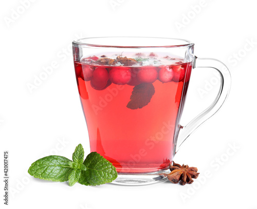 Tasty hot cranberry tea with mint and anise in glass cup on white background