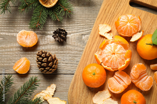 Flat lay Christmas composition with fresh tangerines and fir tree branches on wooden table