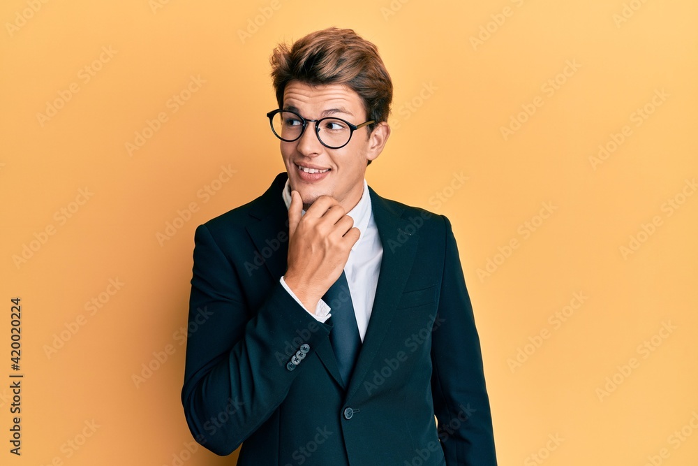 Handsome caucasian man wearing business suit and tie with hand on chin thinking about question, pensive expression. smiling with thoughtful face. doubt concept. Handsome caucasian man wearing business suit and tie with hand on chin thinking about question, pensive expression. smiling with thoughtful face. doubt concept.