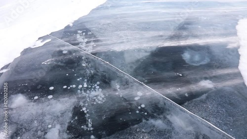 Strong wind drives the wind across the frozen ice surface of Lake Baikal. Siberia, Russia
