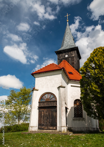 old white church with wooden door and clock tower 
