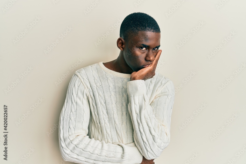 Young african american man wearing casual clothes thinking looking tired and bored with depression problems with crossed arms. Young african american man wearing casual clothes thinking looking tired and bored with depression problems with crossed arms.