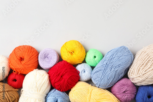Different colorful woolen yarns on white background, flat lay. Space for text