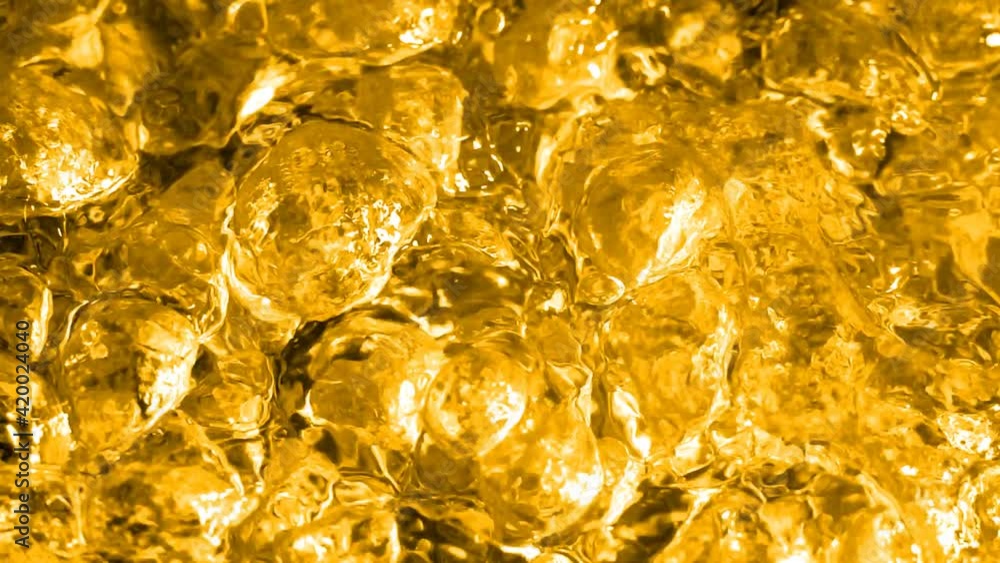 Golden boiling liquid. Intense seething. Visual imitation of molten gold. Slow motion boiling water, tinted gold Golden boiling liquid. Intense seething. Visual imitation of molten gold. Slow motion boiling water, tinted gold