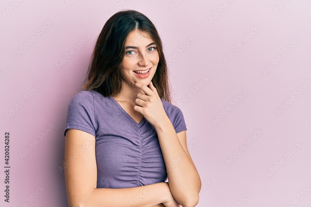 Young caucasian woman wearing casual clothes looking confident at the camera smiling with crossed arms and hand raised on chin. thinking positive. Young caucasian woman wearing casual clothes looking confident at the camera smiling with crossed arms and hand raised on chin. thinking positive.