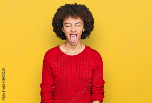 Young hispanic girl wearing casual clothes sticking tongue out happy with funny expression. emotion concept. © Krakenimages.com