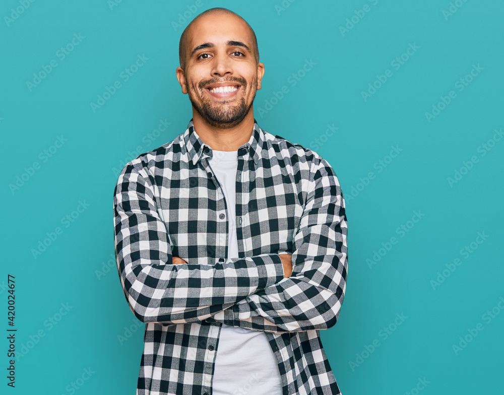 Hispanic adult man wearing casual clothes happy face smiling with crossed arms looking at the camera. positive person. Hispanic adult man wearing casual clothes happy face smiling with crossed arms looking at the camera. positive person.