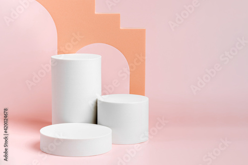 Cylinder podium with stairs and arch. Abstract background with various geometric shapes in pastel color for product presentation. Podium to show cosmetic products.