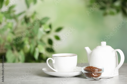 Buckwheat tea and granules on table against blurred background. Space for text