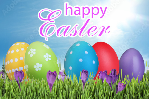 Happy Easter. Bright eggs and spring flowers on green grass outdoors