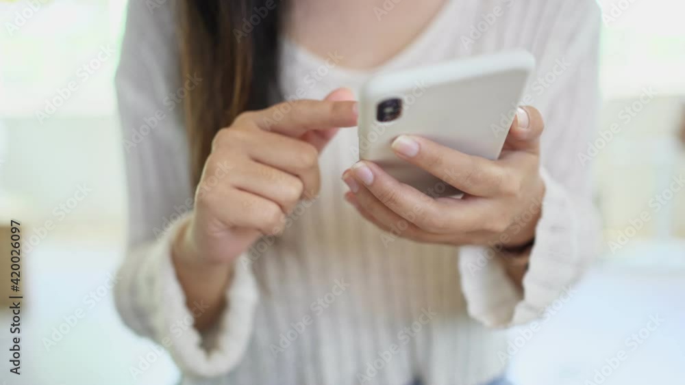 Woman hand using phone pointing finger on screen smartphone texting mobile phone.
Woman hand using phone pointing finger on screen smartphone texting mobile phone.