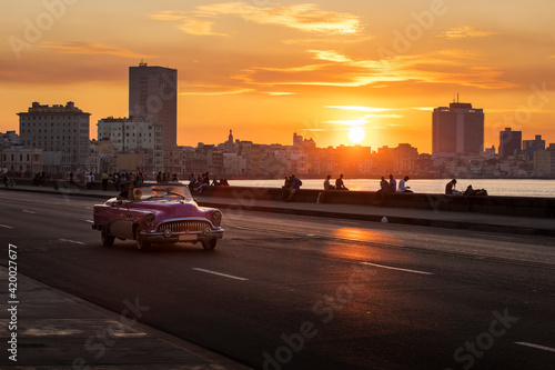 Old car on Malecon street of Havana with colourful sunset in background. Cuba © danmir12