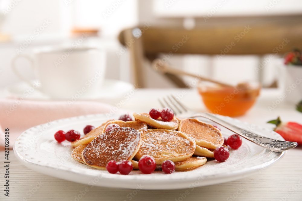 Delicious mini pancakes cereal with cranberries served on white wooden table Delicious mini pancakes cereal with cranberries served on white wooden table