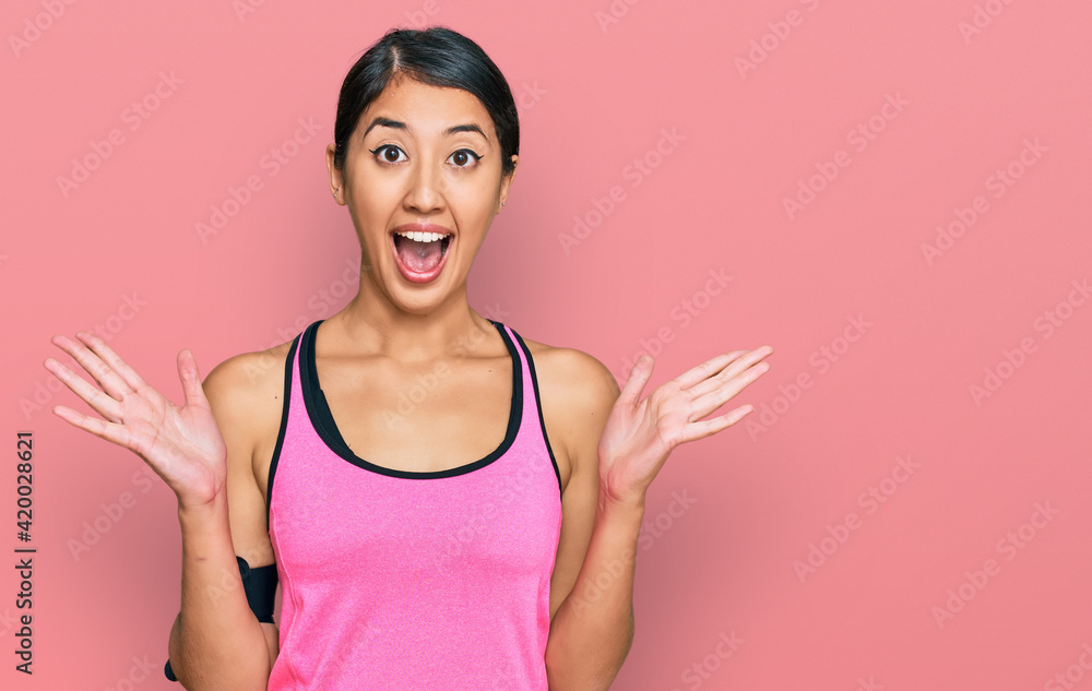 Beautiful asian young sport woman wearing sportswear and arm band celebrating crazy and amazed for success with arms raised and open eyes screaming excited. winner concept Beautiful asian young sport woman wearing sportswear and arm band celebrating crazy and amazed for success with arms raised and open eyes screaming excited. winner concept