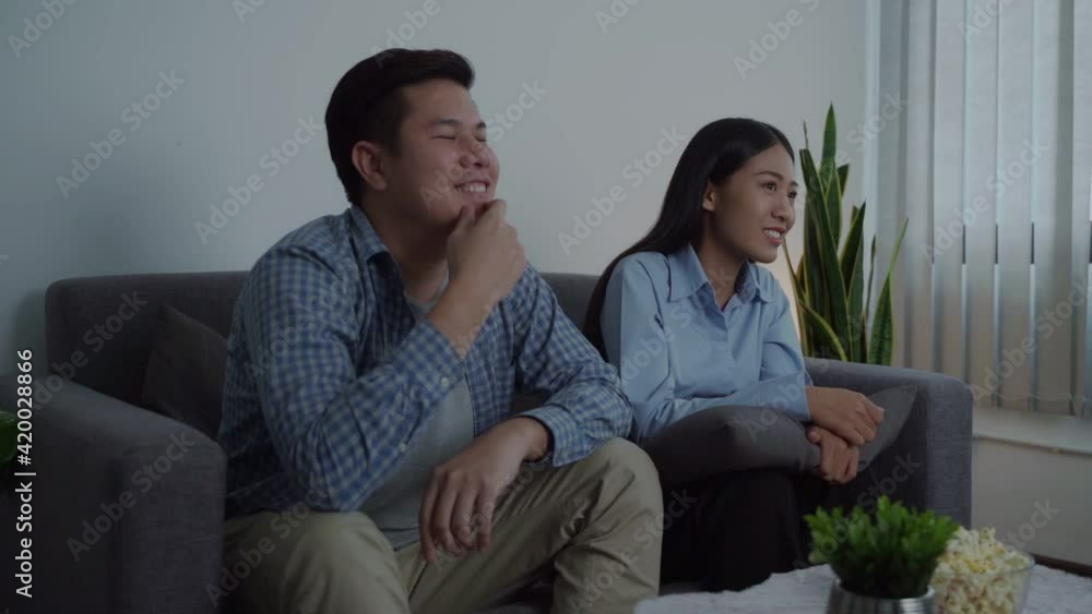 Young couple have fun watching tv together at night time.
Young couple have fun watching tv together at night time.