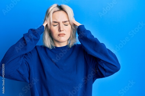 Young blonde girl wearing casual clothes with hand on head, headache because stress. suffering migraine. © Krakenimages.com