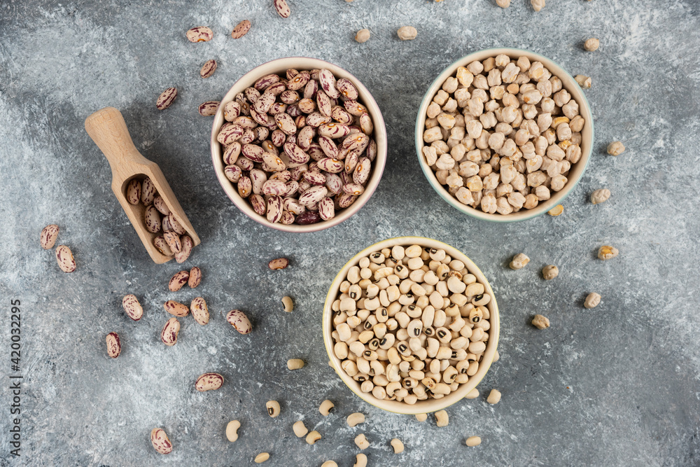 Bowls of various uncooked beans on marble surface Bowls of various uncooked beans on marble surface