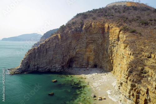 Beach with clear sea water, hill by the sea