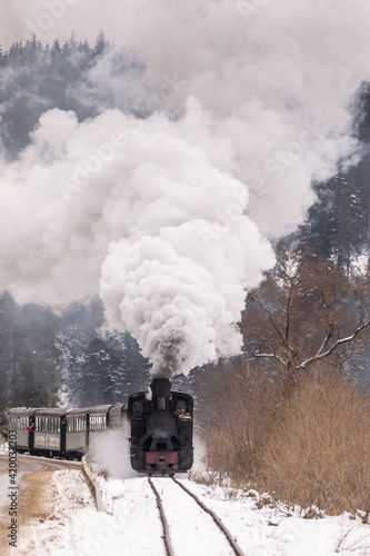 Old train with big smoke during winter time in Moldovita, Bucovina. Romaniia.