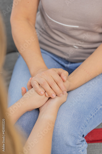 Hands of women hold together in the manner of support and encouragement