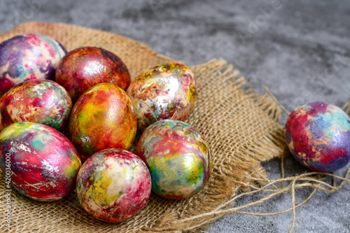 Colorful hand painted purple and rose  easter eggs and  spring blossom on wooden background