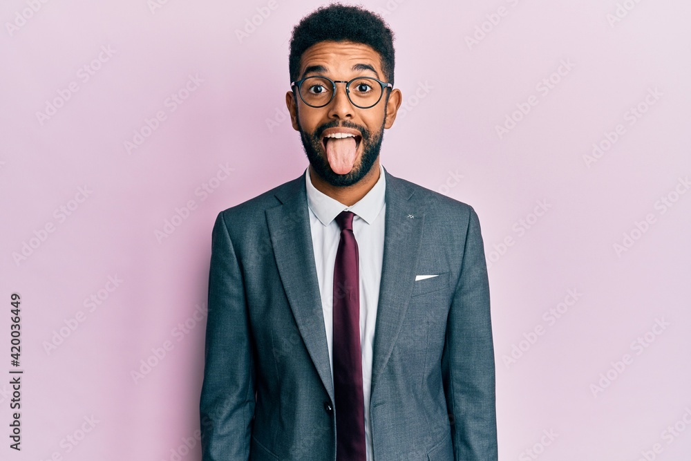Handsome hispanic business man with beard wearing business suit and tie sticking tongue out happy with funny expression. emotion concept. Handsome hispanic business man with beard wearing business suit and tie sticking tongue out happy with funny expression. emotion concept.